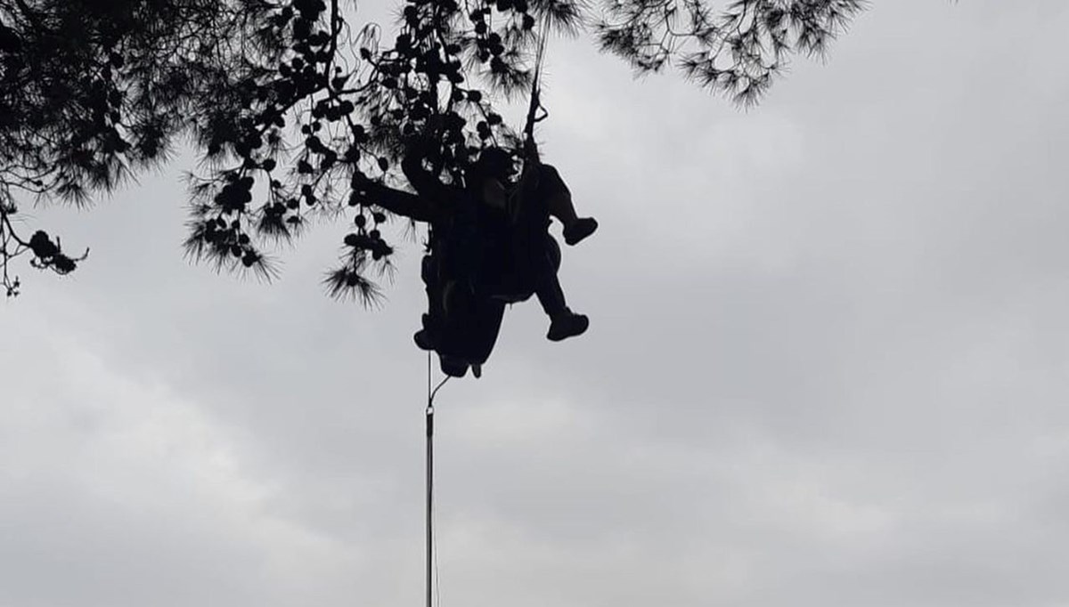 Fırtınanın savurduğu paraşütçü ağaca asılı kaldı